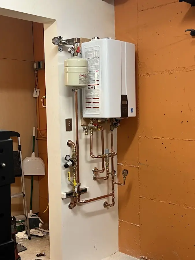 Plumbing technician inspecting water heater connections in Romeoville
